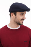 Man in dark blue wool baker boy hat torso view showing cap fit and style