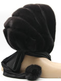 Three-quarter back view dark brown mink black suede striped fur hat hood with black fabric ties and pompons