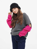 Side profile of woman wearing dark grey wool cloche hat with pink knit sleeve