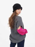 Side view of woman in grey sweater wearing dark grey wool cloche hat