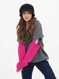 Woman in dark grey cloche hat and grey sweater with pink gloves, close view