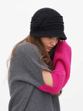 Side view of dark grey wool cloche hat with grey knit sweater