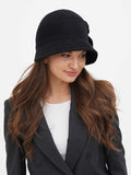 Woman in dark grey cloche hat and white top with blazer, front view