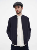 Man wearing dark grey herringbone newsboy cap front view navy jacket
