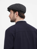 Close-up dark grey herringbone wool newsboy cap texture detail