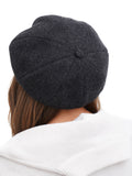 Side profile woman with long hair wearing dark grey cashmere newsboy cap