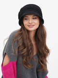 Woman wearing dark grey wool cloche hat with pin-tucked seams, grey sweater