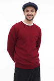 Torso casual view man wearing dark navy 8-panel newsboy cap with burgundy sweater smiling