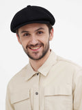 Front close view black newsboy cap on man with beige jacket casual style