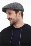 Side profile man wearing graphite grey tweed flat cap with black bomber jacket