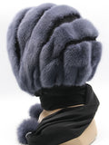 Side profile graphite mink black suede striped fur hat hood on mannequin showing stripe depth and pompons at ties