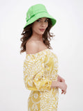 Full-length view of green bucket hat with yellow floral dress