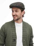 Upper body close-up man in green tweed plaid flat cap showing checkered pattern detail