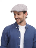 Side profile man in grey newsboy cap showing 8-panel construction with denim outfit