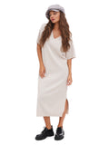 Full body view of woman in grey cotton baker boy cap and white midi dress