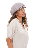 Side profile of woman wearing grey cotton baker boy cap with long hair