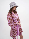 Woman in grey bucket hat adjusting brim, pink printed dress