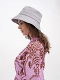 Back view of woman in grey bucket hat and pink floral dress