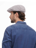 Back view of man wearing grey 8-panel baker boy hat showing construction with denim shirt