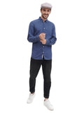 Three quarter view man wearing grey flat cap with denim shirt casual stance