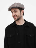 Side profile man wearing grey herringbone newsboy cap showing texture with black shirt