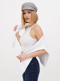 Close-up of woman wearing grey linen baker boy cap with white crop top