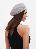 Close-up of grey linen beret on woman's head showing adjustable fit and flat crown detail