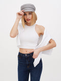 Woman wearing grey linen Breton cap with white crop top, hand on brim