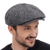 Three quarter angle man in grey tweed newsboy cap with black jacket casual smile