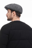 Grey tweed 8-panel newsboy cap front close-up view smiling with black jacket