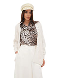 Side view of woman in ivory cotton Greek fisherman cap with leopard print top