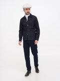 Man in ivory cream linen newsboy cap full body navy outfit standing