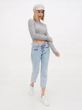Woman walking in ivory linen Breton cap, grey top and light jeans