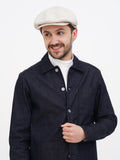 Man wearing ivory linen newsboy cap front view navy jacket casual