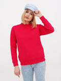 Woman in light blue linen baker boy cap touching brim, red sweater and jeans
