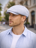 Man wearing light blue linen newsboy hat front view summer street