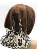 Three-quarter back view light brown mink fur hat hood with warm classic leopard scarf hanging loose