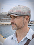 Man wearing light gray plaid linen newsboy hat front view summer outdoors