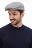 Three quarter view man in light grey tweed flat cap casual smile with navy sweater
