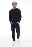 Man wearing light grey tweed newsboy cap with navy sweater full body front view