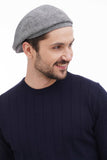 Three quarter casual view man in light grey tweed flat cap with navy sweater