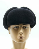 Man wearing black ushanka earflaps secured down front