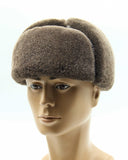 Man wearing brown ushanka earflaps snapped down front