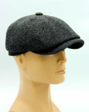 Man in dark tweed newsboy cap eight-panel hat side view
