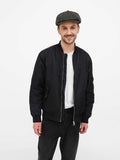 Front view man wearing green slouchy newsboy cap with black bomber jacket