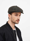 Three quarter view man wearing green newsboy cap with casual black outfit