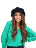 Close-up portrait of woman wearing navy blue 8-panel wool newsboy cap