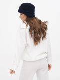 Close-up side view of navy wool cloche hat with cream sweater