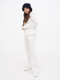 Woman in navy cloche hat and cream sweater, standing, front view