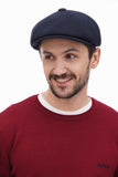 Front close-up man in dark navy tweed newsboy cap with burgundy sweater casual expression